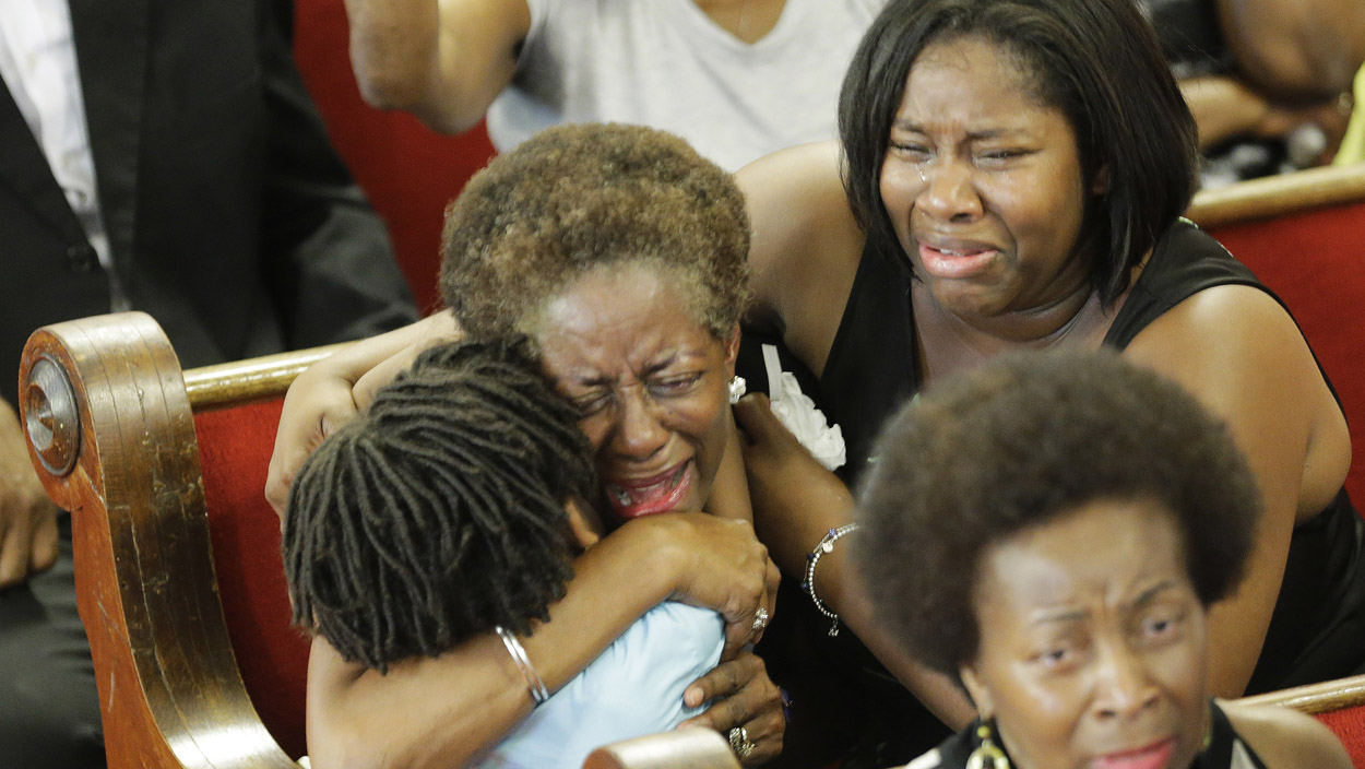 CHARLESTON, SC - JUNE 21:  Parishioners embrace as they attend the first church service four days after a mass shooting that claimed the lives of nine people at the historic Emanuel African Methodist Church June 21, 2015 in Charleston, South Carolina. Chruch elders decided to hold the regularly scheduled Sunday school and worship service as they continue to grieve the shooting death of nine of its members including its pastor earlier this week.  (Photo by David Goldman-Pool/Getty Images)